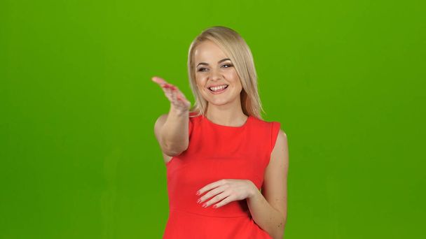 女性で赤で緑の画面の背景ショー彼女の手見ザカメラ - 写真・画像