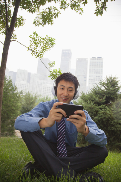Businessman listening to music on his MP4 player - Photo, Image