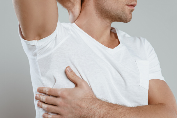 Cropped view of man showing sweaty armpit isolated on grey - Zdjęcie, obraz