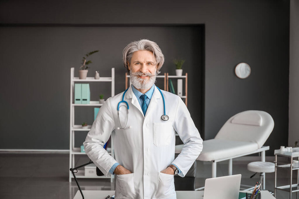 Portrait of senior male doctor in clinic - Foto, afbeelding