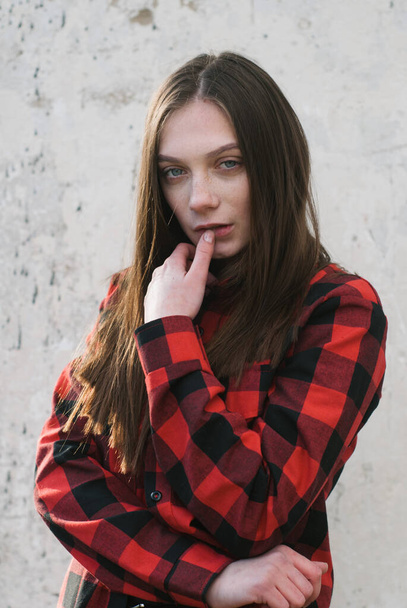 beautiful hipster girl in red shirt posing on white grunge wall background - Valokuva, kuva