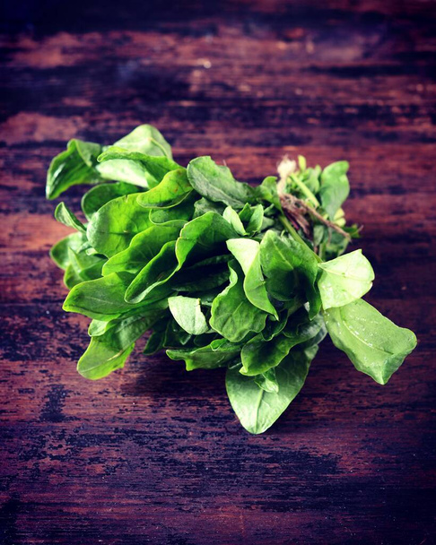 Bunch of fresh spinach (sorrel) on a dark wooden background - Photo, Image