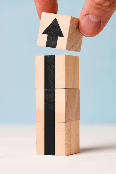 Concepto de negocio exitoso - flecha negra abstracta en cubos de madera. De cerca.
. - Foto, imagen