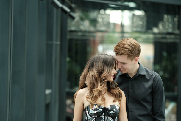 beautiful couple-a girl in a magnificent dress and a guy in a black shirt and trousers are in a building with a beautiful interior - Fotoğraf, Görsel