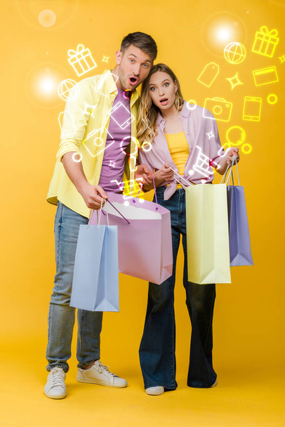 beautiful surprised couple holding shopping bags on yellow, glowing illustration - 写真・画像