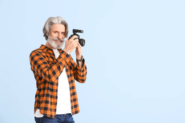 Hezký senior fotograf na barevném pozadí - Fotografie, Obrázek