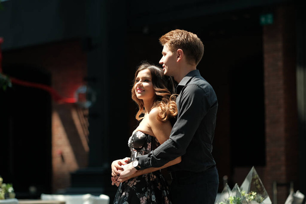 beautiful couple-a girl in a magnificent dress and a guy in a black shirt and trousers are in a building with a beautiful interior - Zdjęcie, obraz