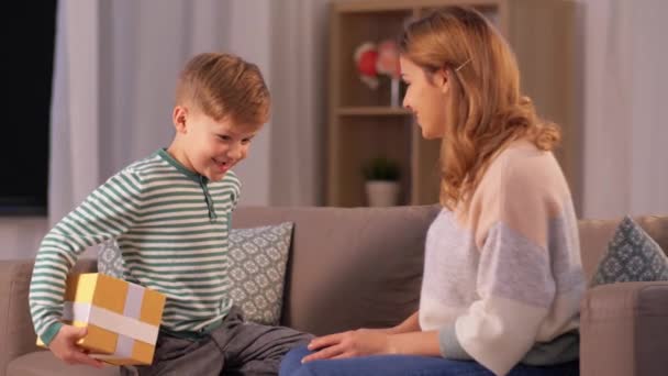 little son giving present to mother at home - Materiał filmowy, wideo