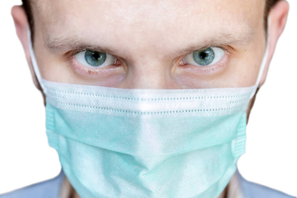 super primer plano de la cara de un hombre con los ojos enojados en una máscara médica
 - Foto, imagen