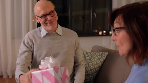 happy senior couple with gift box at home - Felvétel, videó