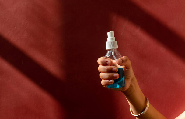 Vista de las cosechas de manos de niño joven aplicando aerosol de alcohol contra el virus. Aerosol antiséptico para prevenir la propagación de gérmenes, bacterias, coronavirus y virus. Antiséptico y desinfectante
. - Foto, imagen