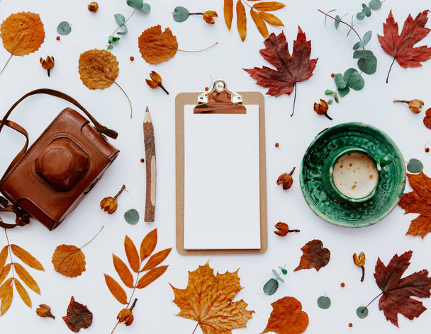 Home office table desk workspace with clipboard decorated with autumn leaves and coffee cup. Flat lay, top view freelance business concept for social media, magazine - Foto, Imagen