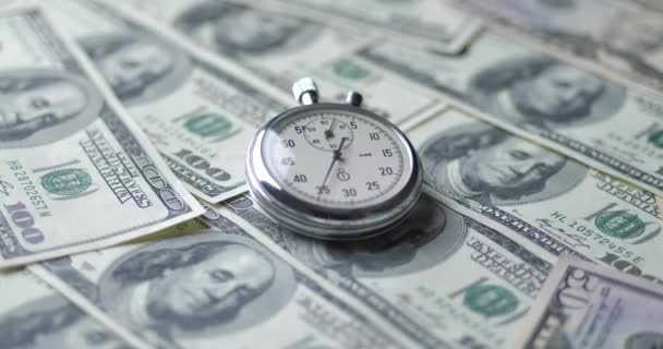 De stopwatch ligt op de dollars. Tijd is geld concept. - Video