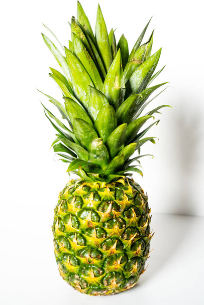Eine ganze Ananas vor einem schlichten weißen Hintergrund - Foto, Bild