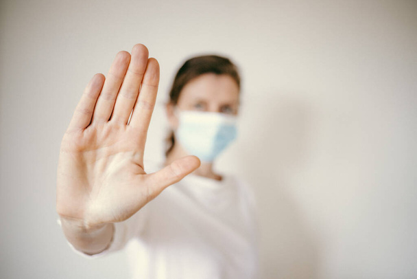 зупинити коронавірусну жінку в медичній масці та підняти руку бійка 2019-nCoV розповсюдження
 - Фото, зображення