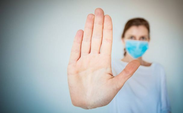 医療マスクを着用したストップコロナウイルス女と手を上げる2019-nCV戦-広がり - 写真・画像