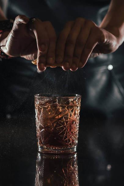 bartender sprinkles orange over cocktail - Photo, Image
