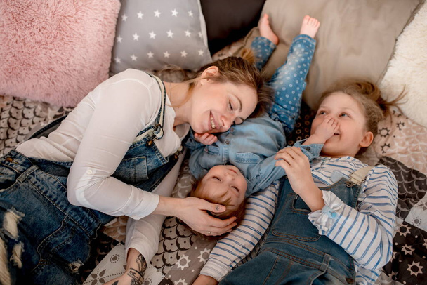 Mom and daughters in jeans clothes at home - Foto, Bild