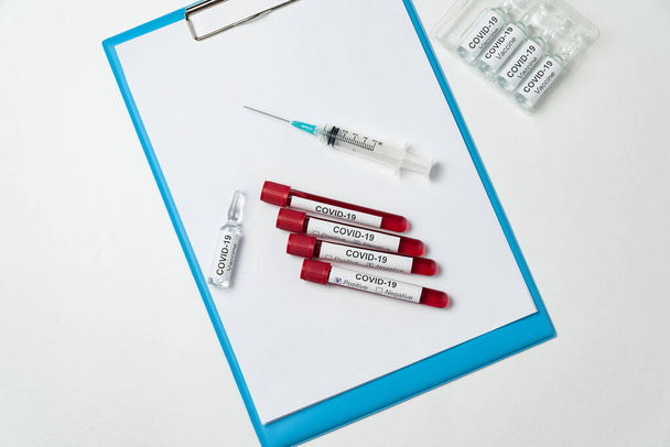 Test tubes of blood, syringe and vial of vaccine for coronavirus. Top view. Treatment of 2019-nCov. - Fotografie, Obrázek