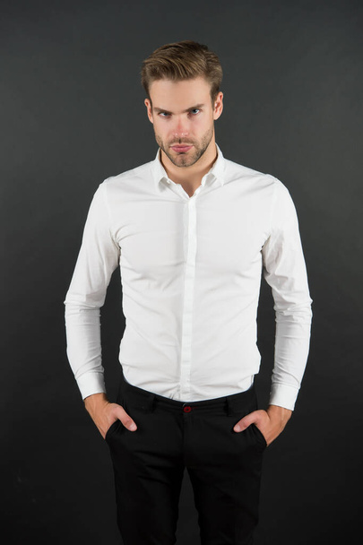 Wear it simple. White shirt and black pants. Serious man dark background. Fashion look of handsome guy. Fashion model in classic style. Fashion and style. Ready to go fashion wardrobe - Fotó, kép
