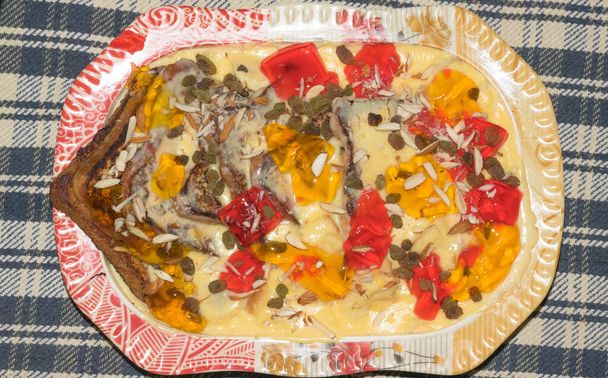 Leves lekváros darabokkal, hagyományos ízletes desszert sodóval, lekvárral és száraz gyümölcsökkel.. - Fotó, kép