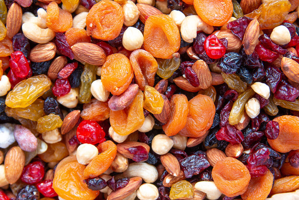 Dried fruits with nuts. Cashew, hazelnuts, peanuts, dried apricots, viburnum, raisins. - Foto, imagen