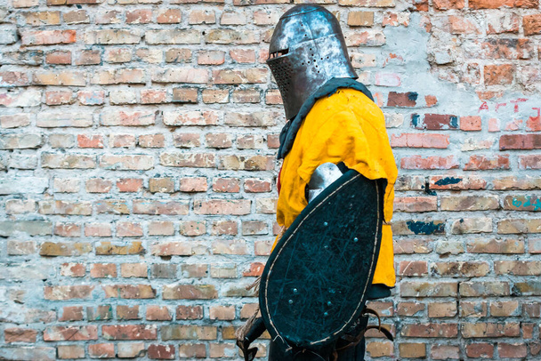 Middeleeuwse ridder in harnas. In gele imitatie, herstel van militaire operaties, gevechten. - Foto, afbeelding