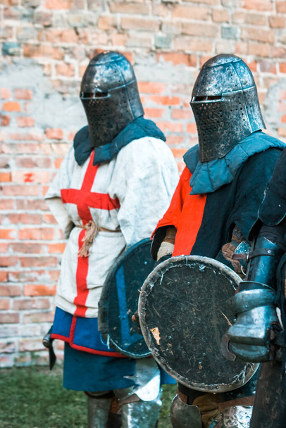 Two medieval knights in armor. With a cross. Imitation, restoration of military operations, fights. - Фото, изображение