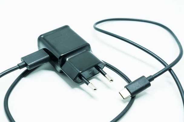 Зарядное устройство смартфона с USB-кабелем, изолированное на белом фоне
 - Фото, изображение