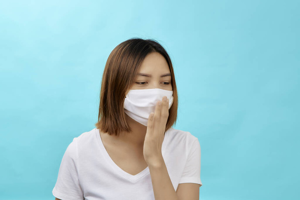 Ázsiai nő barna hajjal és orvosi maszkkal a védelem újra influenza világoskék háttér. Másold le az SMS-ed helyét. COVID-19 harci koncepció. - Fotó, kép
