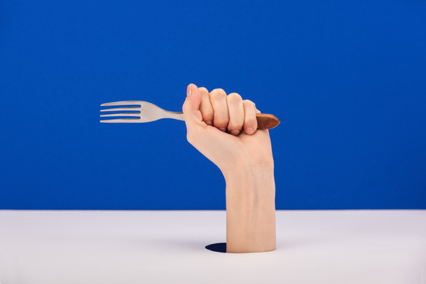 cropped view of woman holding fork isolated on blue - Foto, Bild