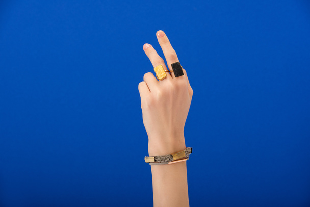 cropped view of woman with bracelet and rings isolated on blue - Foto, Imagem