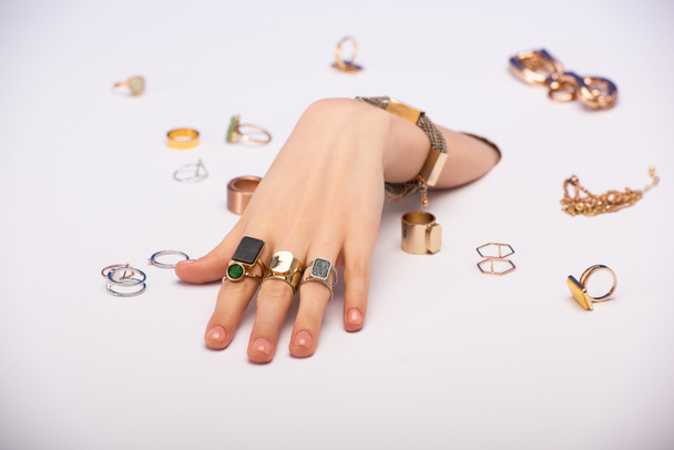 vista recortada de mujer con brazalete en la mano cerca de anillos de oro en blanco
  - Foto, imagen