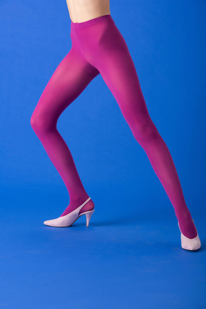cropped view of woman in bright purple tights and heels standing on blue - Фото, изображение