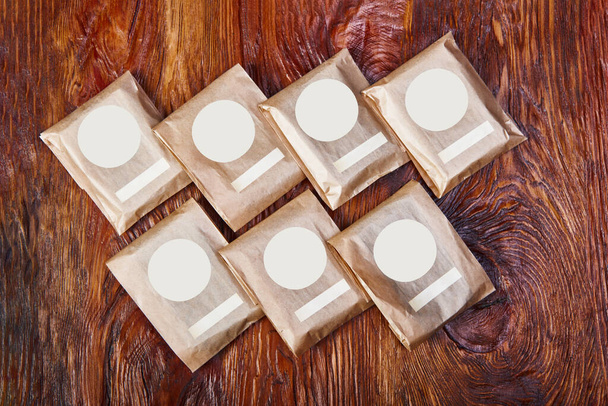 Natürliche handgefertigte Seifenstäbe auf Holzgrund. Spa Bio-Seife in Ökopapierverpackungen. - Foto, Bild
