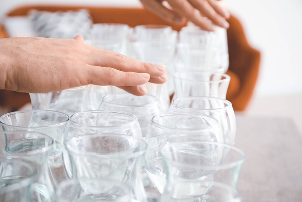 Young man playing music on glasses with water at home, closeup - Photo, Image