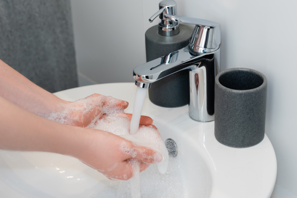 обрізаний вид дівчини миття мильних рук у ванній
  - Фото, зображення