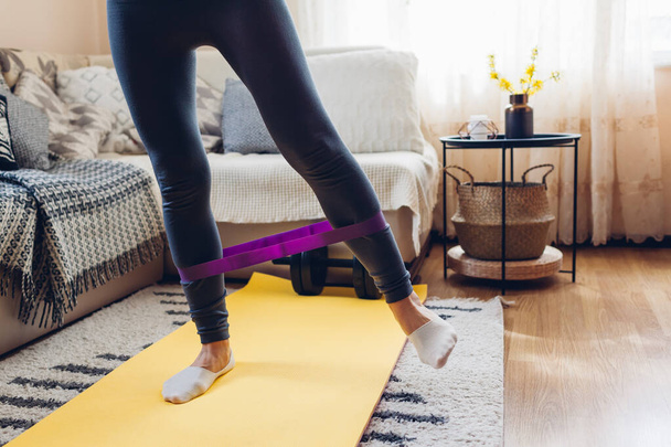 Home workout during coronavirus quarantine. Woman training using mat sport belt. Booty glutes building, legs excercise - Foto, Imagem