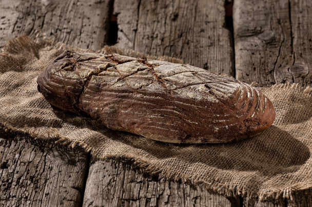 Čerstvý pečený chléb u dřevěného stolu - Fotografie, Obrázek
