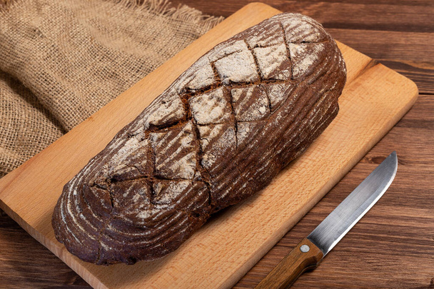 Fresh baked bread at wooden table - Fotó, kép