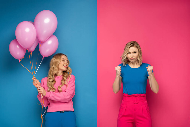 Attractive blonde girl with balloons sticking out tongue near angry sister on blue and pink background - Fotografie, Obrázek