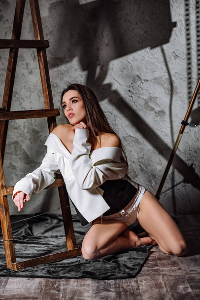 Girl in a Jacket, and Sexy Lingerie Posing in a Studio. Model sensually posing in retro loft interior. - Φωτογραφία, εικόνα