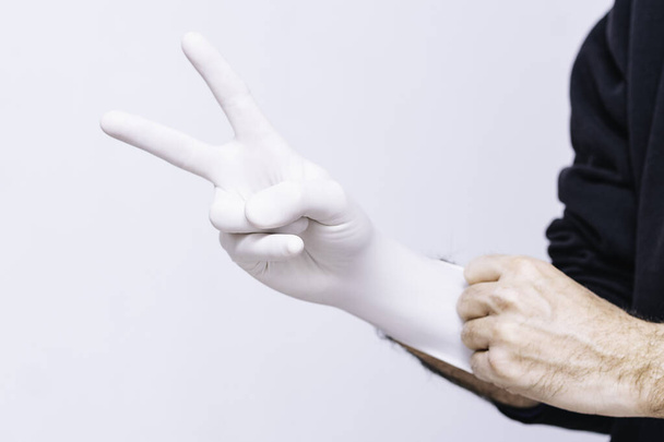 ラテックス手袋の医師は勝利のシンボルを作る - 写真・画像
