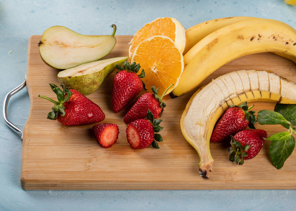 Tropical fruit combination on a wooden board, top view - Zdjęcie, obraz