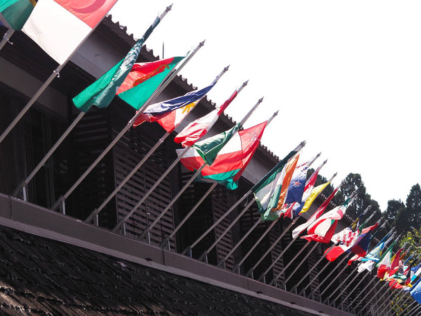 Bandera de diferentes países ondeando en el viento en el edificio
  - Foto, Imagen
