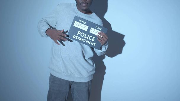 Gangster posiert auf der Polizeiwache für ein Foto - Foto, Bild