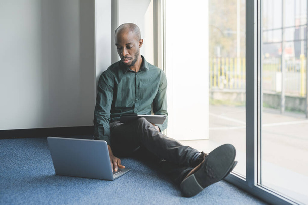 Junger gutaussehender schwarzer Mann im Innenraum Smart Working - Business, Freelancer, Selbstisolierungs-Konzept - Foto, Bild