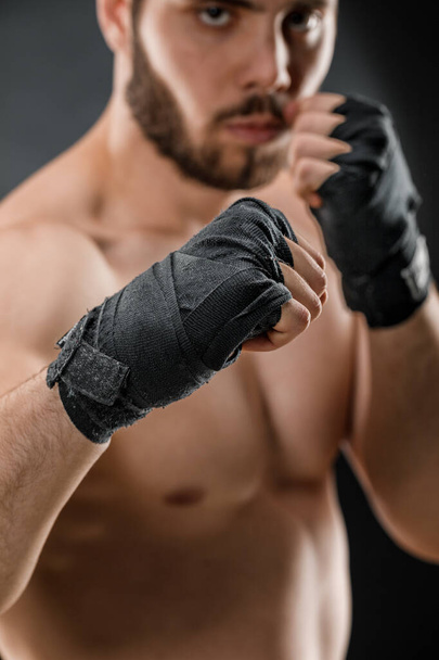 Close-up of a male boxer's hand with Boxing bandages. Fists of a fighter before a fight or training in the gym. The concept of sport - Foto, imagen