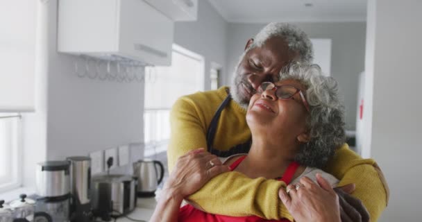 A senior African American couple spending time at home together, social distancing and self isolation in quarantine lockdown during coronavirus covid 19 epidemic, embracing, smiling in slow motion - 映像、動画