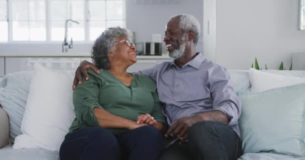 Portrait of a senior African American couple spending time at home together, social distancing and self isolation in quarantine lockdown during coronavirus covid 19 epidemic, looking at camera, smiling, embracing in slow motion - Metraje, vídeo